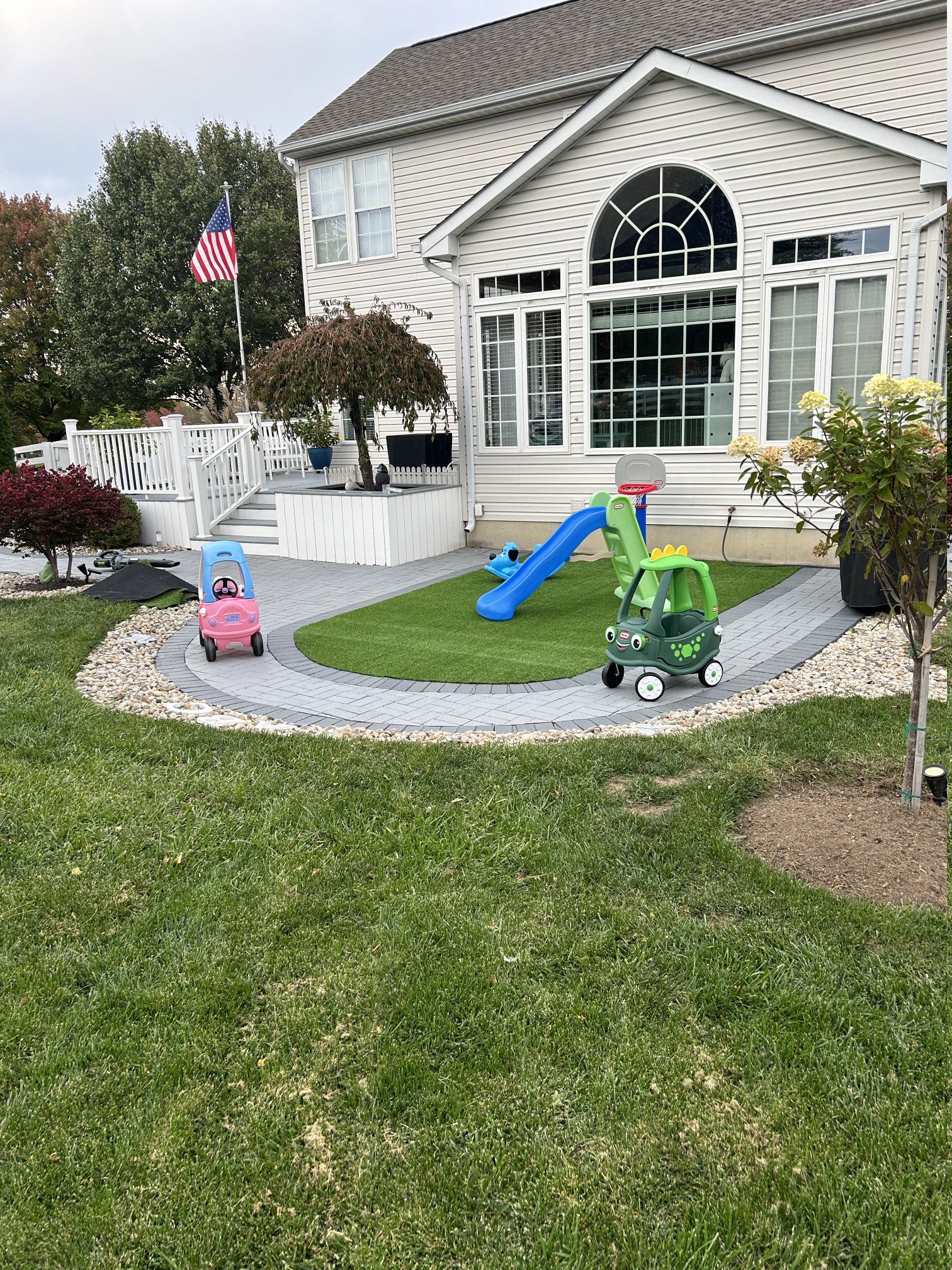 Outdoor play area with slide, ride-on toys, and artificial turf at Cottontail