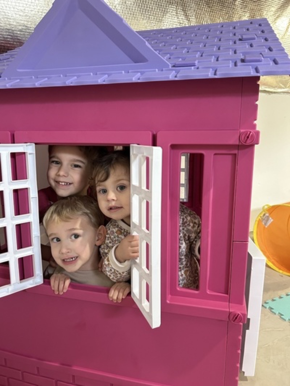 Children peeking out of a playhouse window