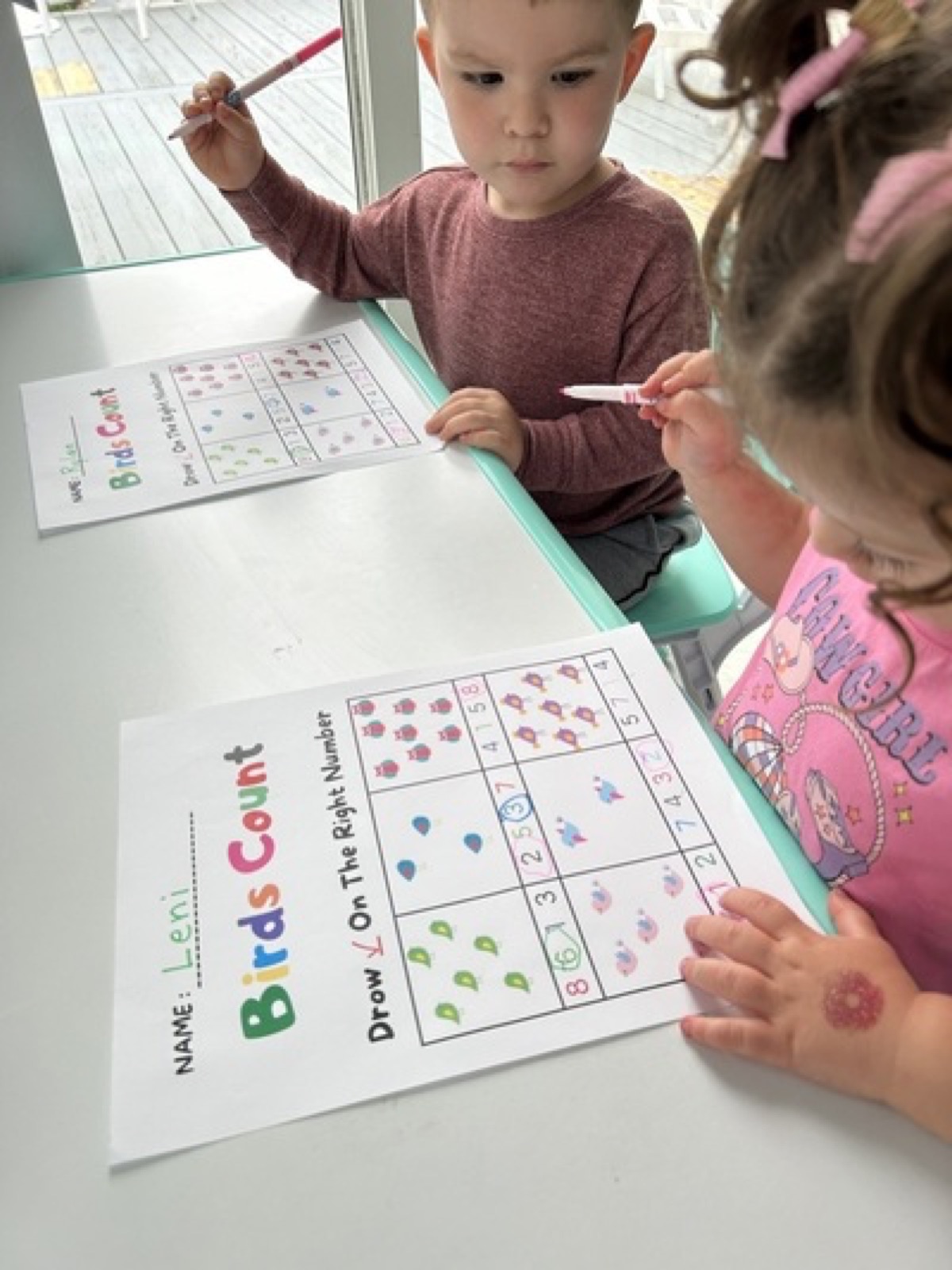 Children working on counting worksheets at a table