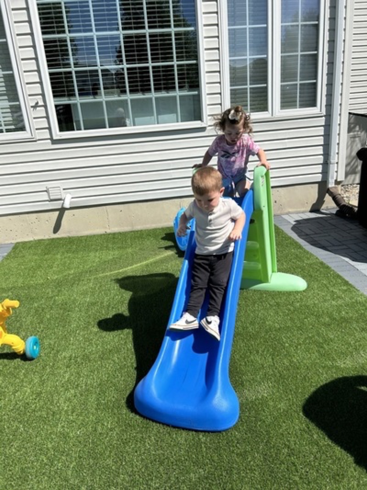 Children taking turns on the outdoor slide